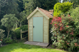 Wooden shed with a green door in a garden setting